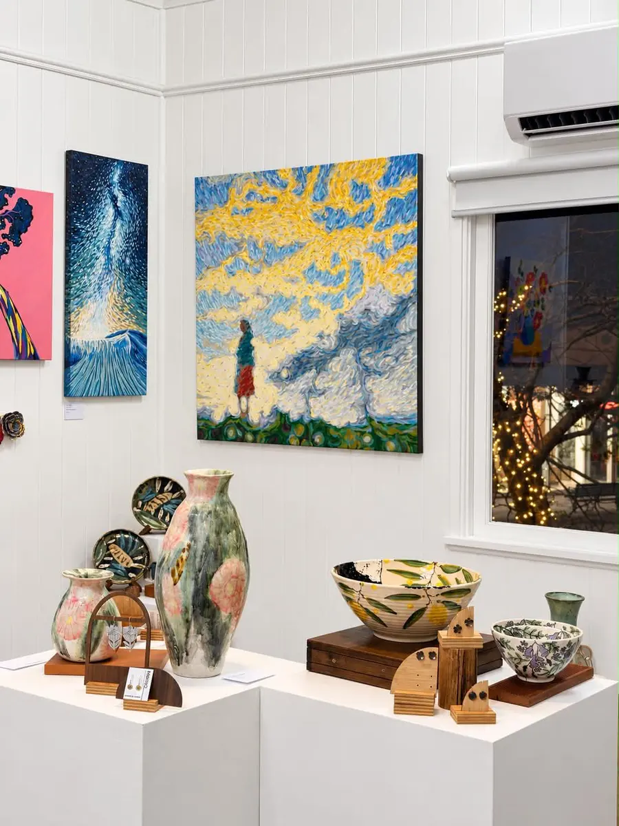 A corner of the gallery with paintings, vases and bowls