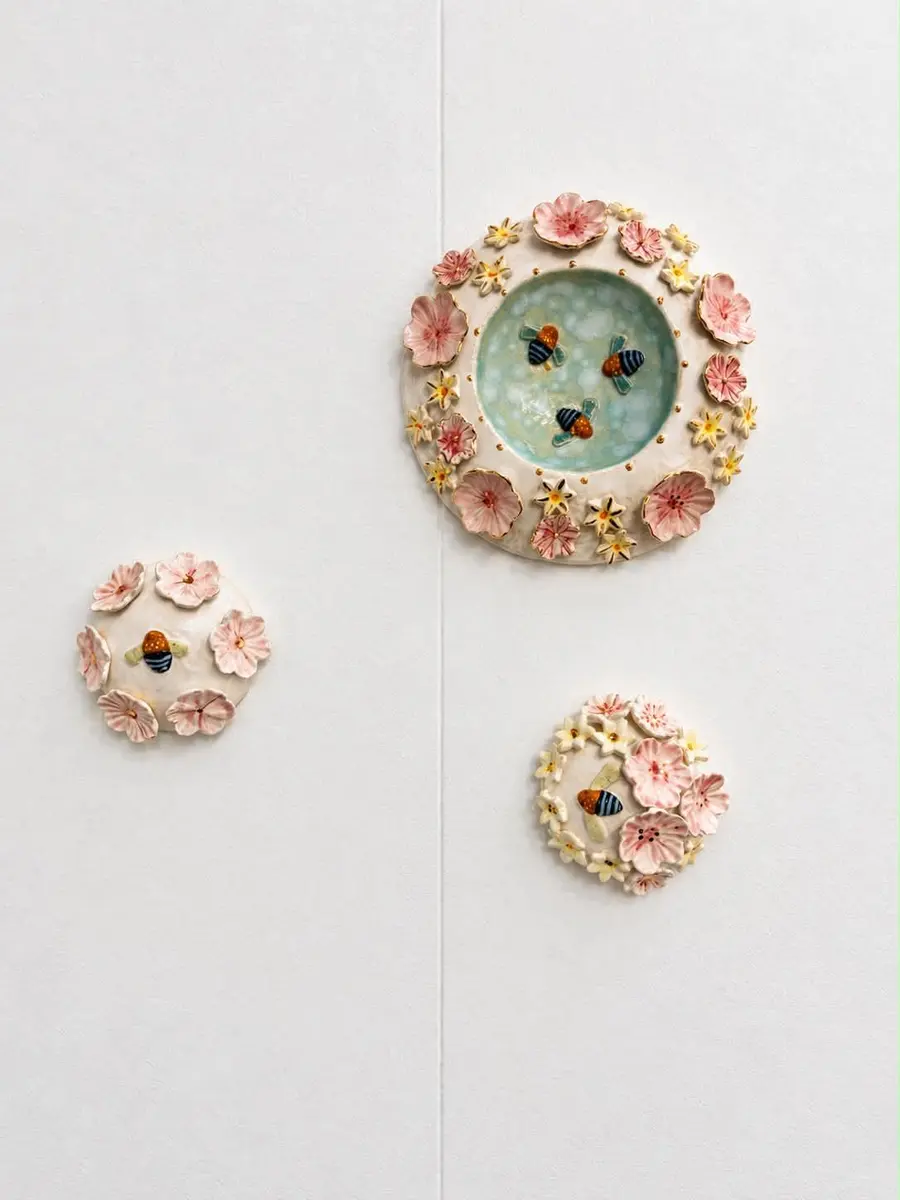 Ceramic flower wall pieces on a white wall