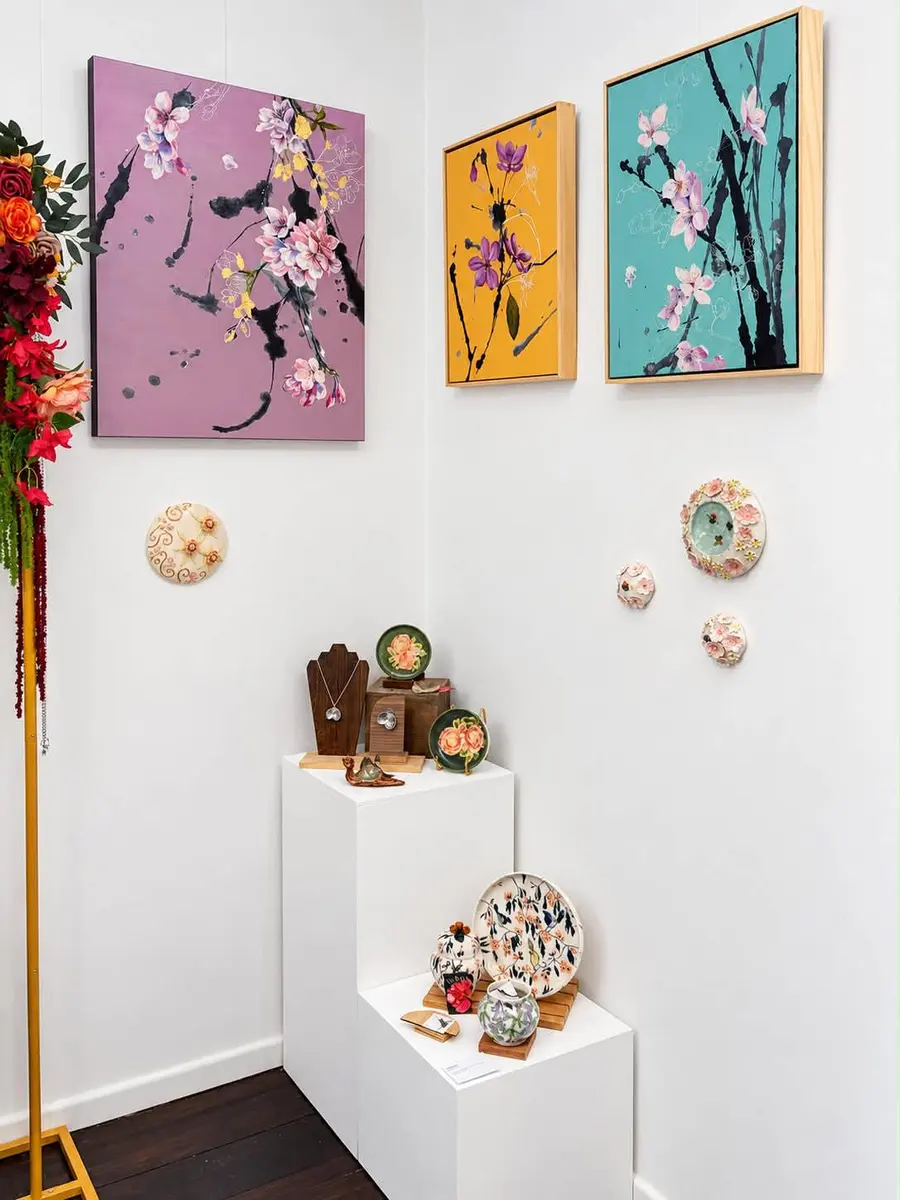 Blossom paintings above ceramic wall flowers and plinths