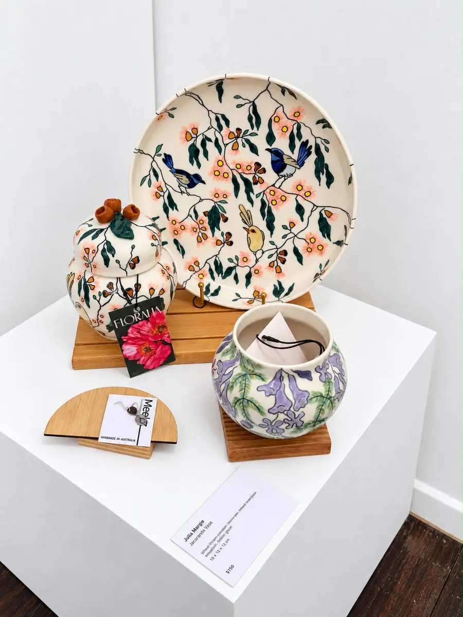 Hand-painted platters and a lidded jar on a plinth